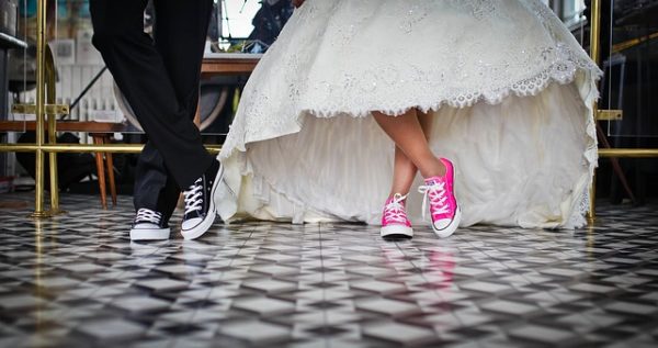 Bride and groom with converse on their feet in their wedding attire at wedding shows